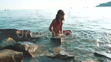 <strong>小女孩</strong>用石头和石头在海里<strong>洗澡</strong>。少女少女在生活方式的浪花上游泳